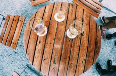 Types of beer mats; a round wooden table with drinks placed on coasters