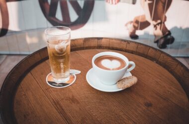 personalised beermats; a glass of chilled beer on a beermat and a cup of coffee placed on a wooden table