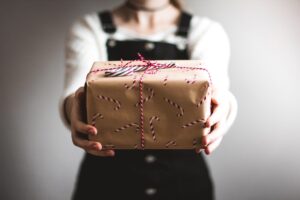 A person holding a nicely wrapped gift in their hand