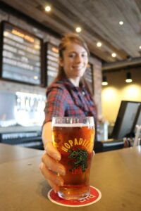 Uses of beermats; A woman serving beer placed on a coaster