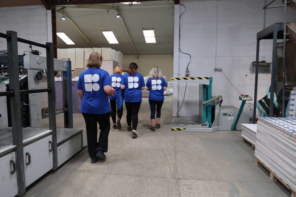 company logo uniform, female Mosaic BoardPrint employees wearing matching t-shirts walking away