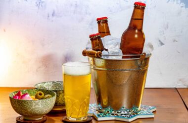 pub beer mats, chilled beer besides snacks on wooden table