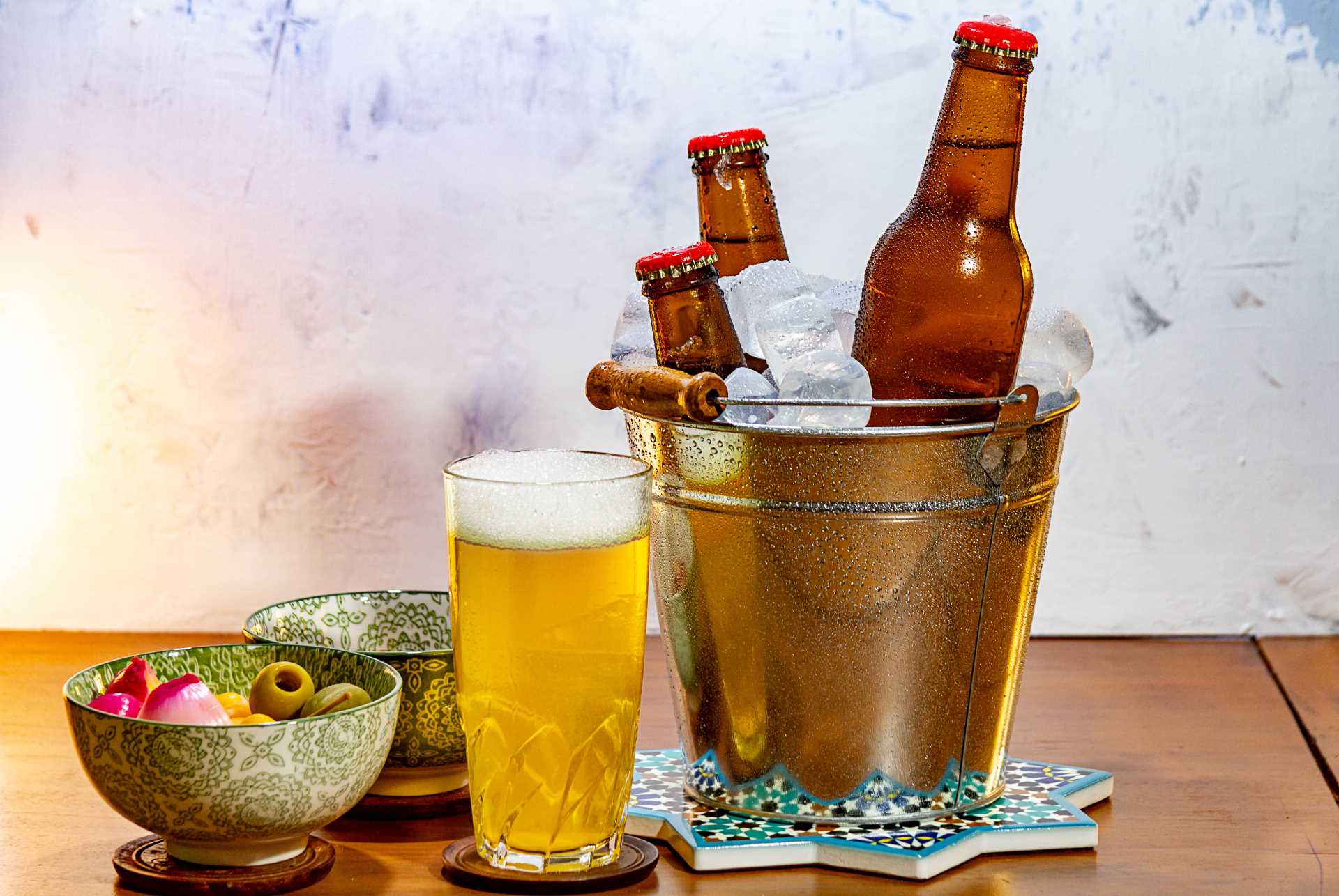 pub beer mats, chilled beer besides snacks on wooden table