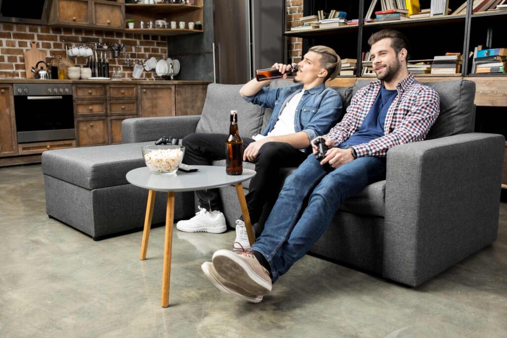 traditional pub beer mats, two men on couch sipping beer